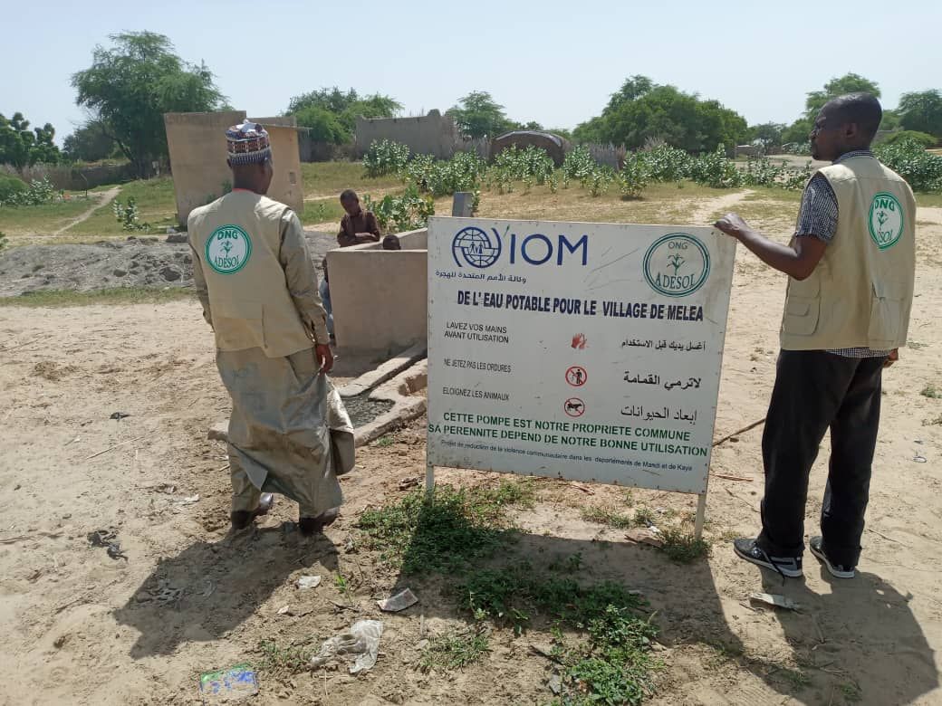 Panneau « De l'eau potable pour le village de Melea », OIM et ONG ADESOL
